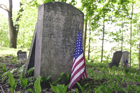 A flag honors the grave of Revolutionary War veteran Jacob Scofield Jr. in a small, historic burial ground known as Simsbury Cemetery at High Ridge Road and Cross Road in Stamford.