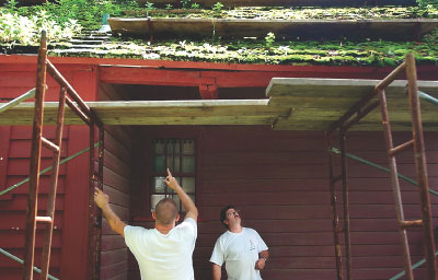 David Hipkins, left, and Stephen Hoyt inspect the roof yesterday of the Hoyt-Barnum House, Stamford’s oldest house. Hoyt, a distant relative of the man who built the home, and workers from his firm are installing a new cedar shingle roof