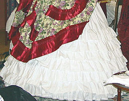 A full skirt fits on top of the  ruffled overpetticoat which covers the hooped crinoline.